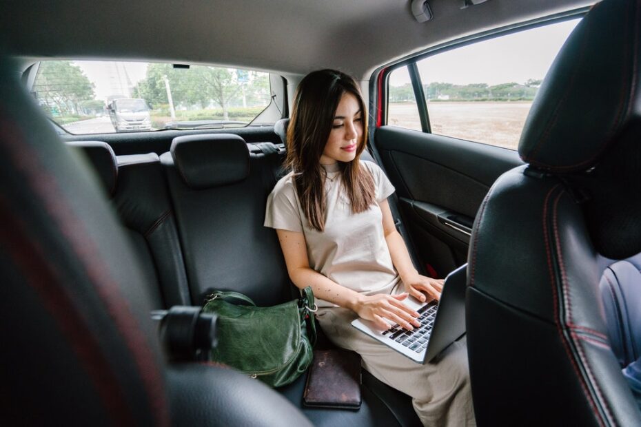Woman using a laptop in the car